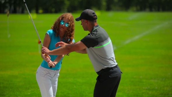 Young Man Train Woman How To Hit Ball In Golf alt