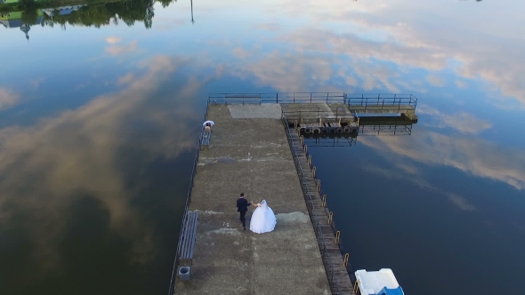 The Bride And Groom Running Through The Marina, 