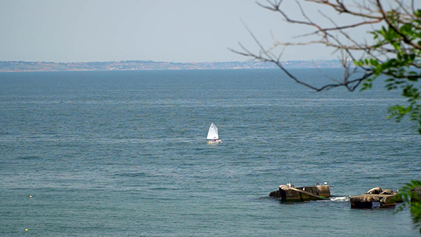 The Yacht Floating in the Sea. On the Far Bank Can Be Seen the City