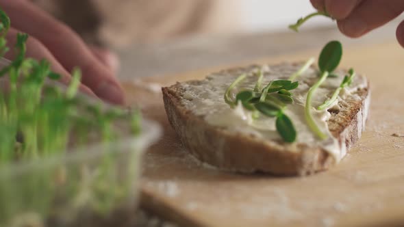 Making sandwich proper nutrition. A slice of whole grain bread with riccotta on bamboo bread board alt