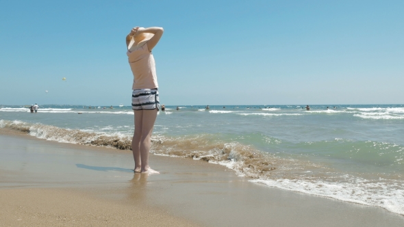 Woman Is Standing At The Beach With a Jute Hat On