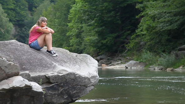 Young Beautiful Girl Sitting On The Big Stone Near Mountain River