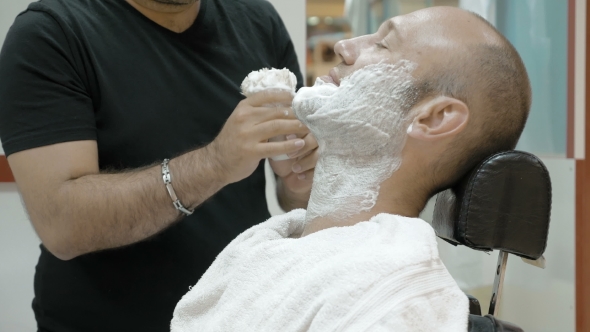 A Man Is Sitting At a Barber's Shop To Get Groomed