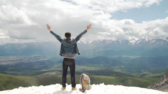Hiker With Backpack Standing On Top Of a Mountain With Raised Hands And Enjoying Sunrise. alt