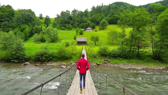 Man Walk Across a Suspension Bridge. alt