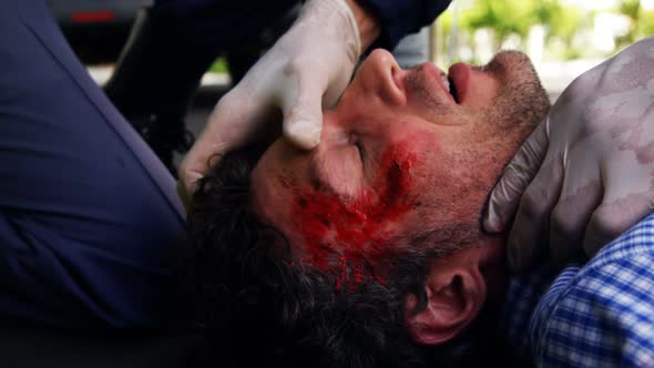 Emergency medical technician taking car an injured man alt