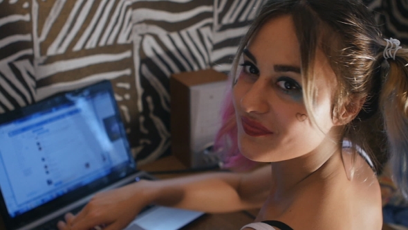 Teenage Girl At Laptop Looks At Camera And Doing The Thumbs Up alt