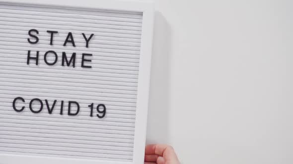 STAY HOME and COVID19 Sign on Message Board with a Homemade Face Mask alt