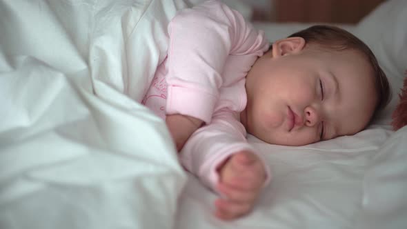 Authentic Portrait Cute Caucasian Little Infant Chubby Baby Girl or Boy in Pink Sleep with Teddy alt