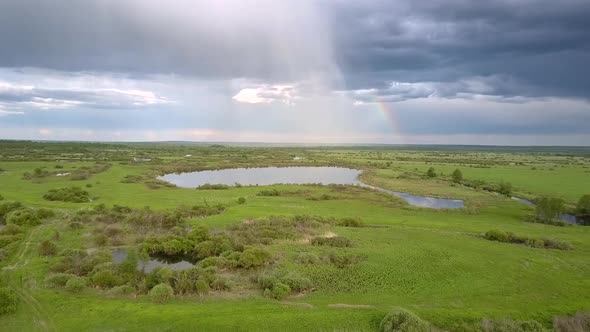 Tremendous Lake Surrounded By Green Meadows Under Clouds alt