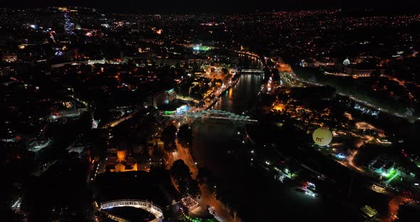 Night aerial view of Bridge of Peace and beautiful cityscape in the center of Tbilisi, Georgia 2022 alt