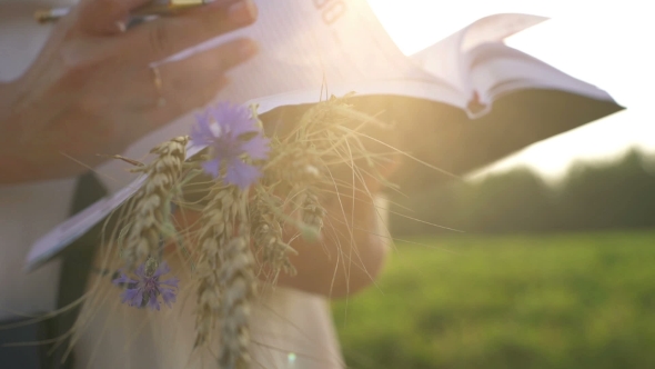 Girl With Pen Writing On Notebook On Grass Outside