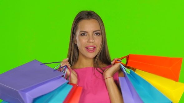 Woman Holding Shopping Bags And Smiling alt