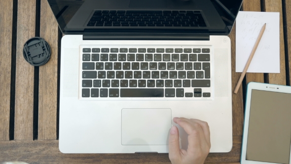 A Person Is Typing On His Laptop. Top View POV. alt