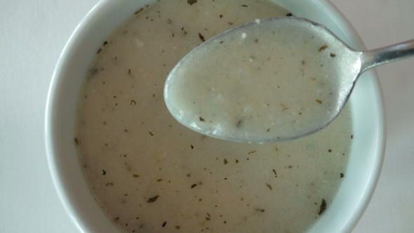 A Bowl Filled With White Creamy Soup With Spices