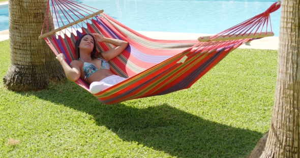 Relaxing Young Woman In Colorful Hammock alt