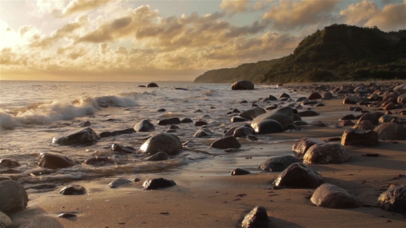 Beautiful Sea Coast With Stones in the Background of the Rising Sun.