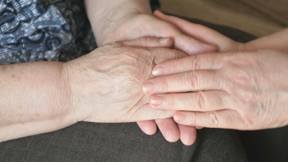 Woman Strokes An Old Wrinkled Woman's Hand