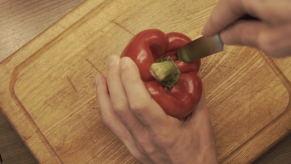 Male Hands Preparing Paprika On a Wooden Cooking Board