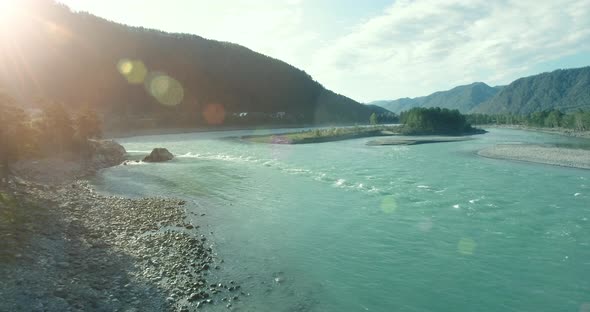Low Altitude Flight Over Fresh Fast Mountain River with Rocks at Sunny Summer Morning. alt