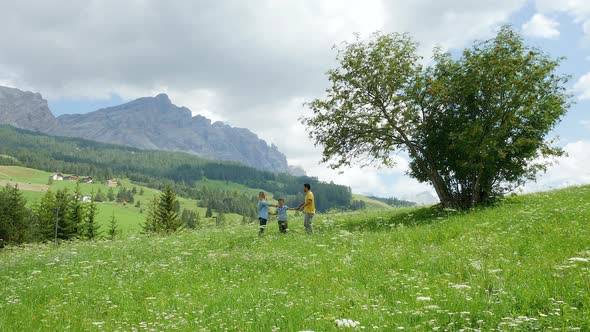 Family with son (8 to 9) in Alpine meadow, Alta Badia, Italy