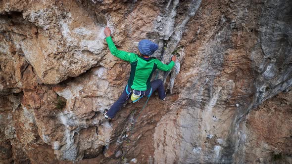 Slow Motion Aerial View Strong Female Rock Climber Climbs on Overhanging Cliff By Hard Route with alt