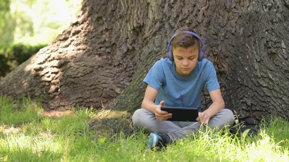 Boy With Tablet At Park