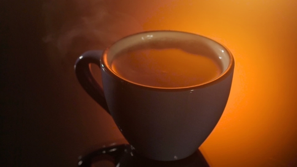 Black Tea In Blue Cup With Steam Above On Shiny Background, Warm Evening Atmosphere,