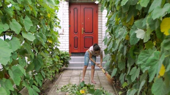 Woman Cleans Up In The Yard.