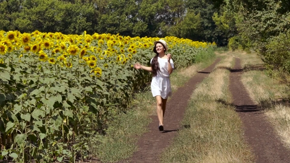 Woman Runs Across The Road Near a Field Of Sunflowers