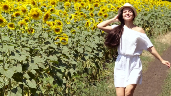 Woman Runs Across The Road Near a Field Of Sunflowers