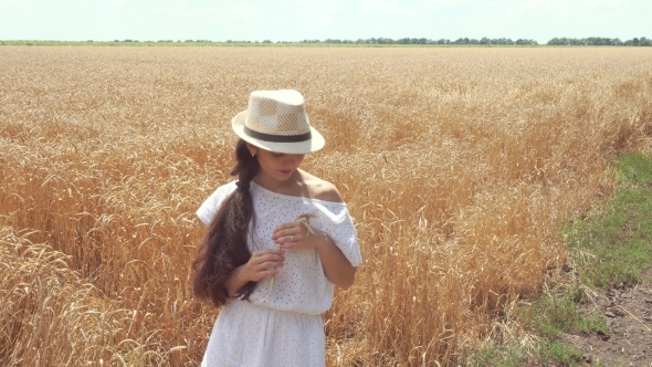 Woman In White Dress Standing In Field Holding Wheat Ears