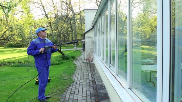 Professional Man Cleaning Dirty Windows With High Pressure Water Jet