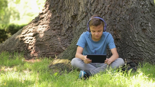 Boy With Tablet At Park