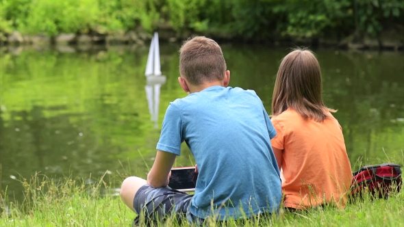 Children With Remote Controlled Boat