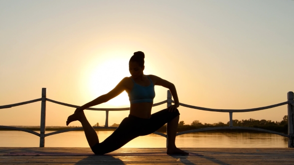 Woman Practicing Yoga On The Beach At Sunset. Healthy Active Lifestyle Concept alt