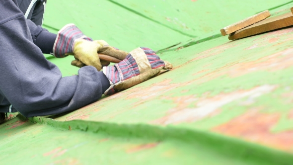 Worker Scraping off Green Paint