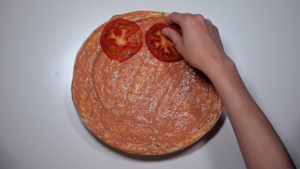 Woman's Hands Laying Out Tomato Slice On Round Dough For Preparing Pizza