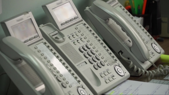 Hand Picks Up The Phone And Dials a Number On The Phone.