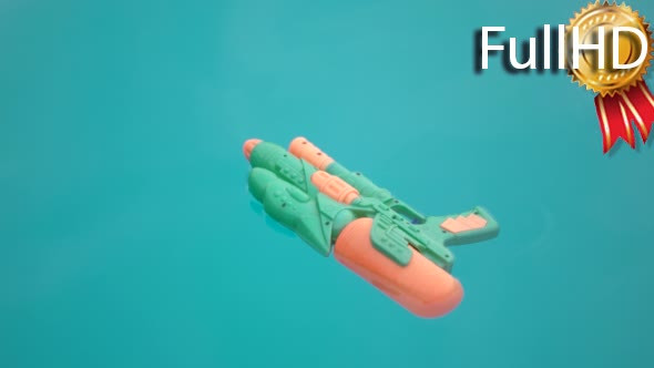 Water Gun Floating in a Blue Swimming Pool Water