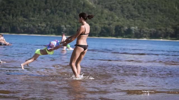 Mother Playing Turning Around Her Baby Girl Daughter In The Lake alt