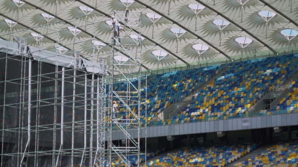 Working Raise Rope Standing In a Construction Ladder On The Big Stadium. alt