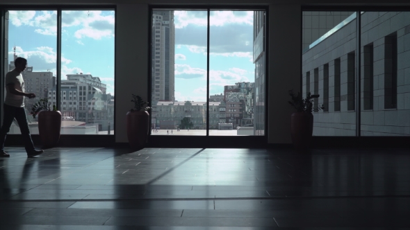 Athletic Man In Bright Shirt Is a Dark Corridor, Sometimes Looking At The Phone. alt