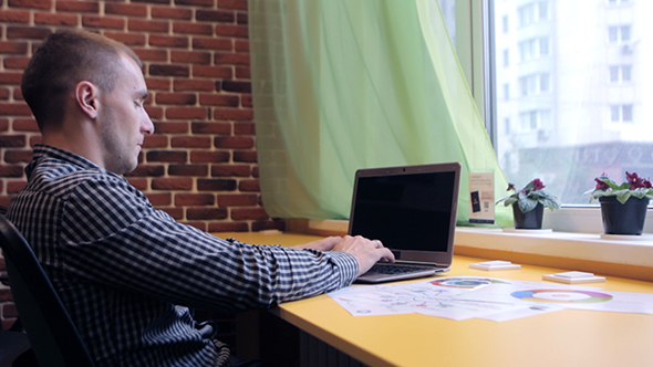  A Man Working On a Laptop And Analyzes The Graph