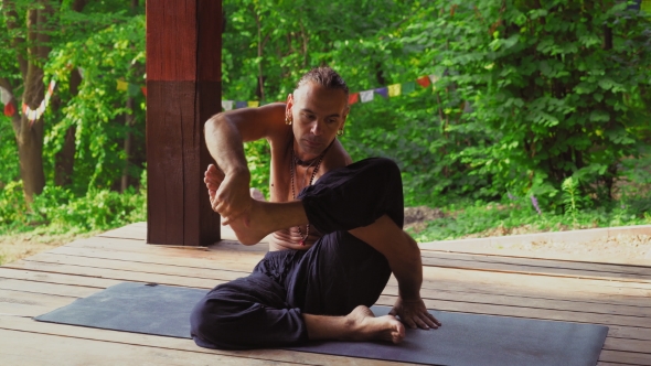 The Man In The Park Demonstrates Exercises With Yoga. alt
