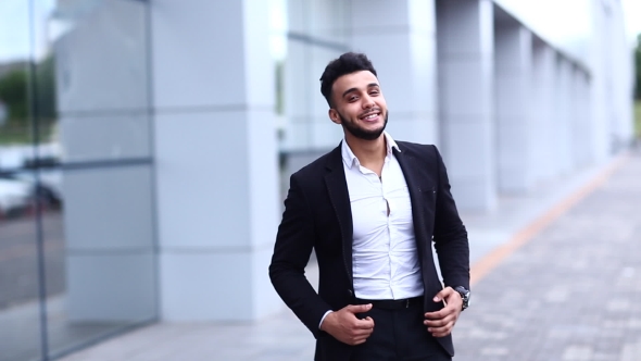 Arabic Guy In Business Center Stands Smiling Walking Slow