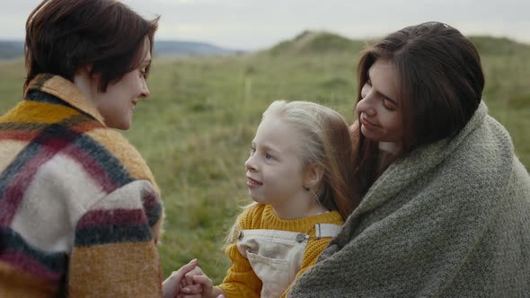 Female Parents Spending Free Time with Daughter Outdoors alt