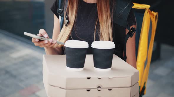 Close Up of Young Woman Delivery Worker Standing at Street and Holding Carton alt