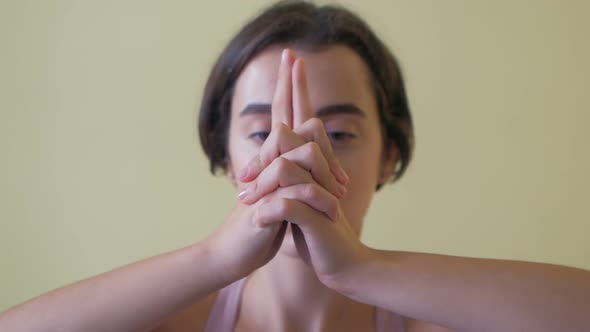 Thin girl in activewear doing yoga exercise Garudasana or Eagle pose with bare feet on mat in sports alt