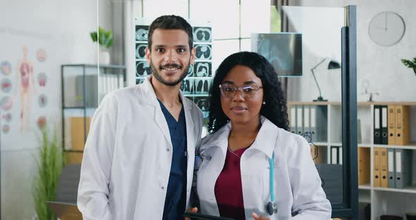 Mixed Race Doctors which Standing in front of Camera in Medical Room in Modern Hospital alt